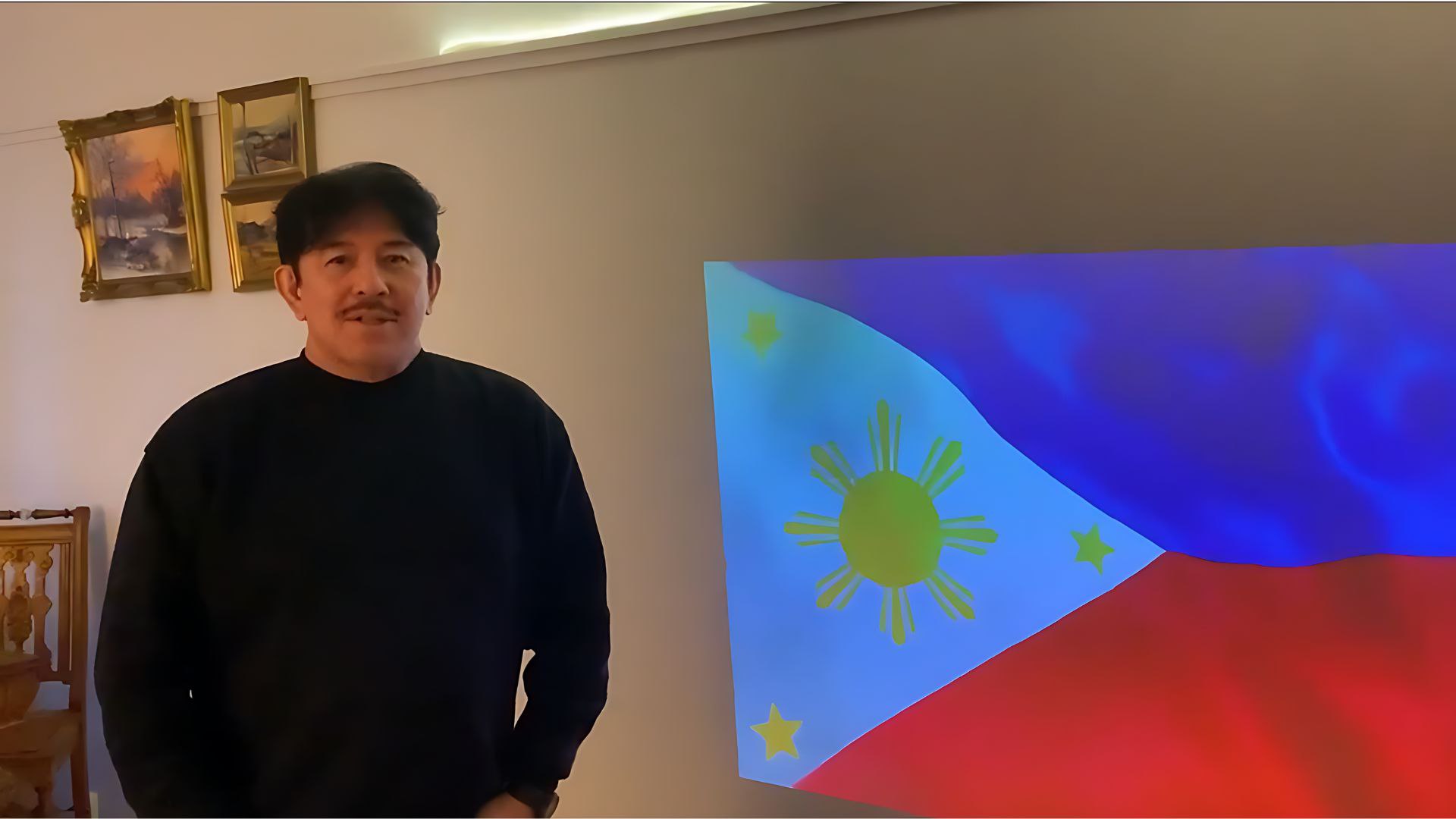 Atty. Raul Dado standing next to a Philippine Flag, delivering a message about TSOK and its tenth anniversary.